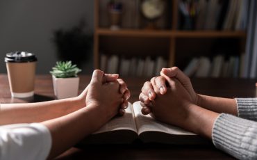 Group of different women praying together, Christians and Bible study concept.